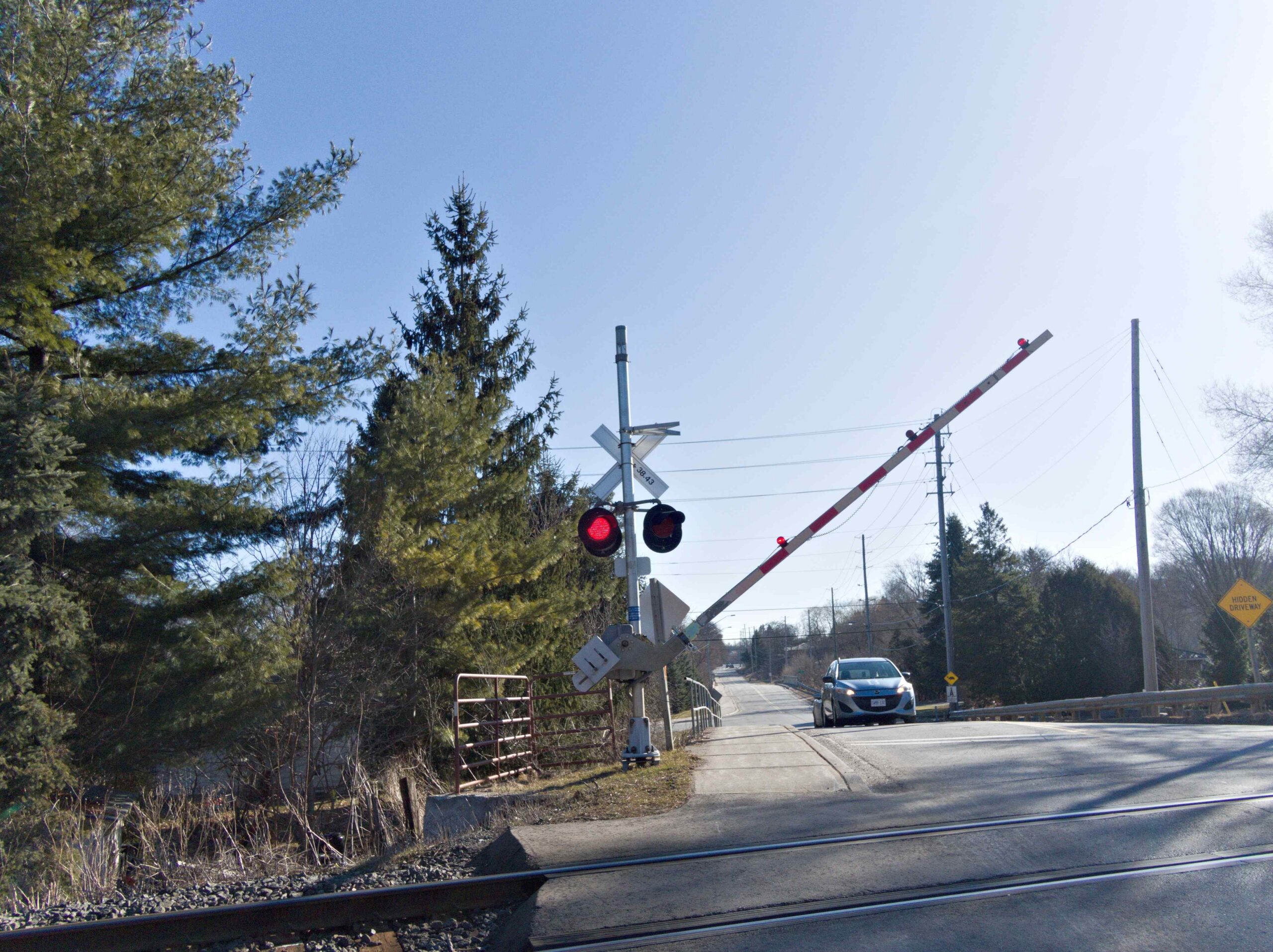 Railroad crossing with gate arm and warning lights on a rural road